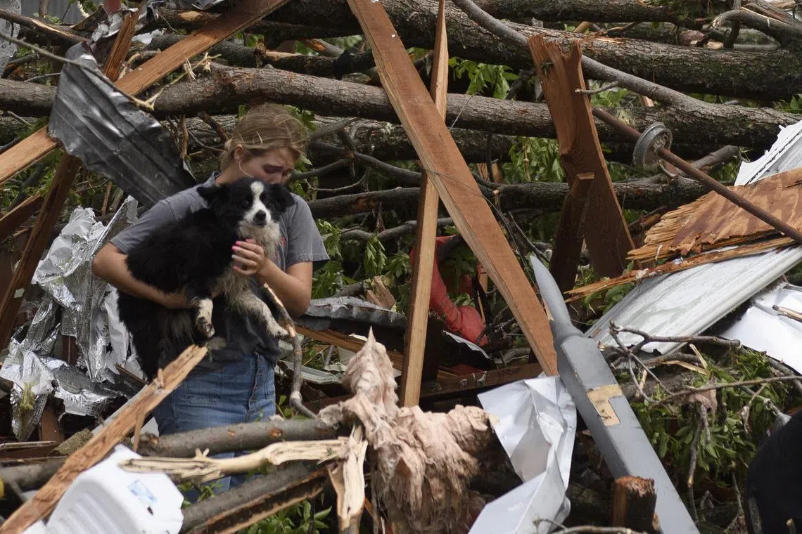 Ms Payton McClure is seen with her dog Jack in Oklahoma, following a series of tornadoes that swept through the area.