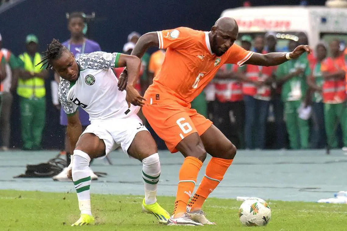Soccer Football - Africa Cup of Nations - Group A - Ivory Coast v Nigeria - Olympic Stadium of Ebimpe, Abidjan, Ivory Coast - January 18, 2024  Ivory Coast's Serge Aurier in action with Nigeria's Seko Fofana  REUTERS/Stringer