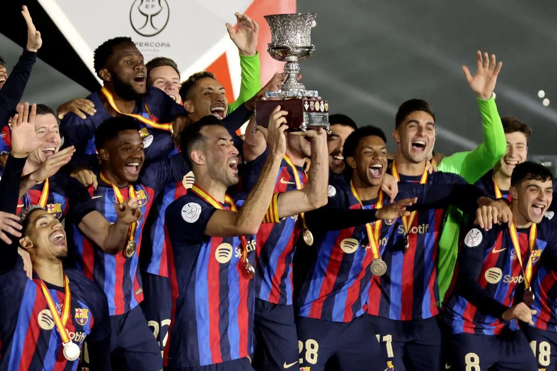 FC Barcelona's Sergio Busquets lifts the trophy as he celebrates with teammates after winning the Spanish Super Cup.