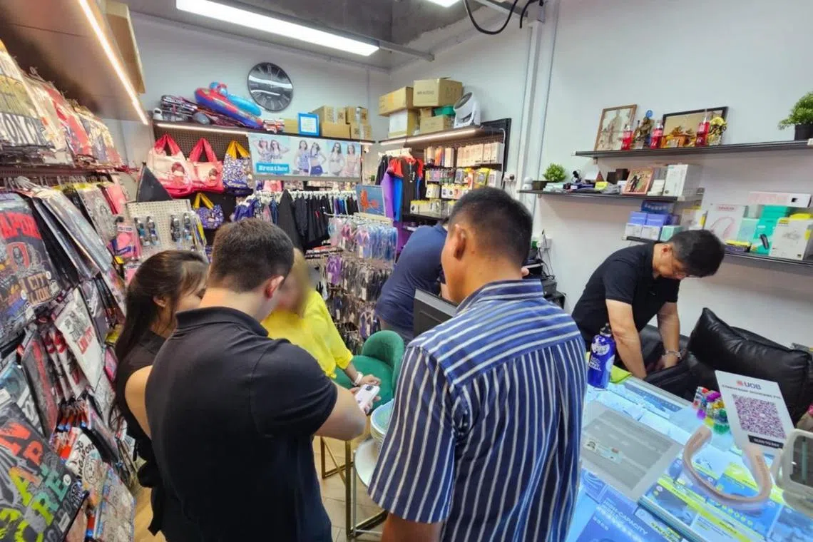 Police officers conducted simultaneous raids on eight mobile phone shops.