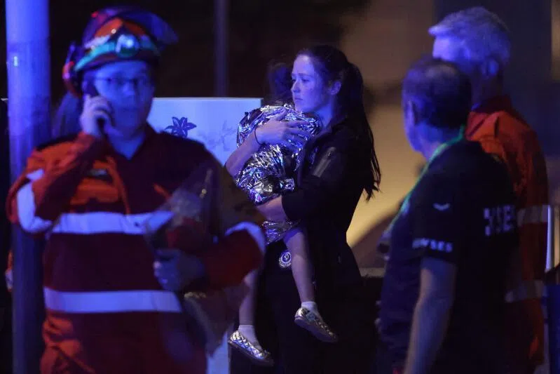A woman a child in a blanket after a shooting incident at Bondi Beach in Sydney on Dec 14.