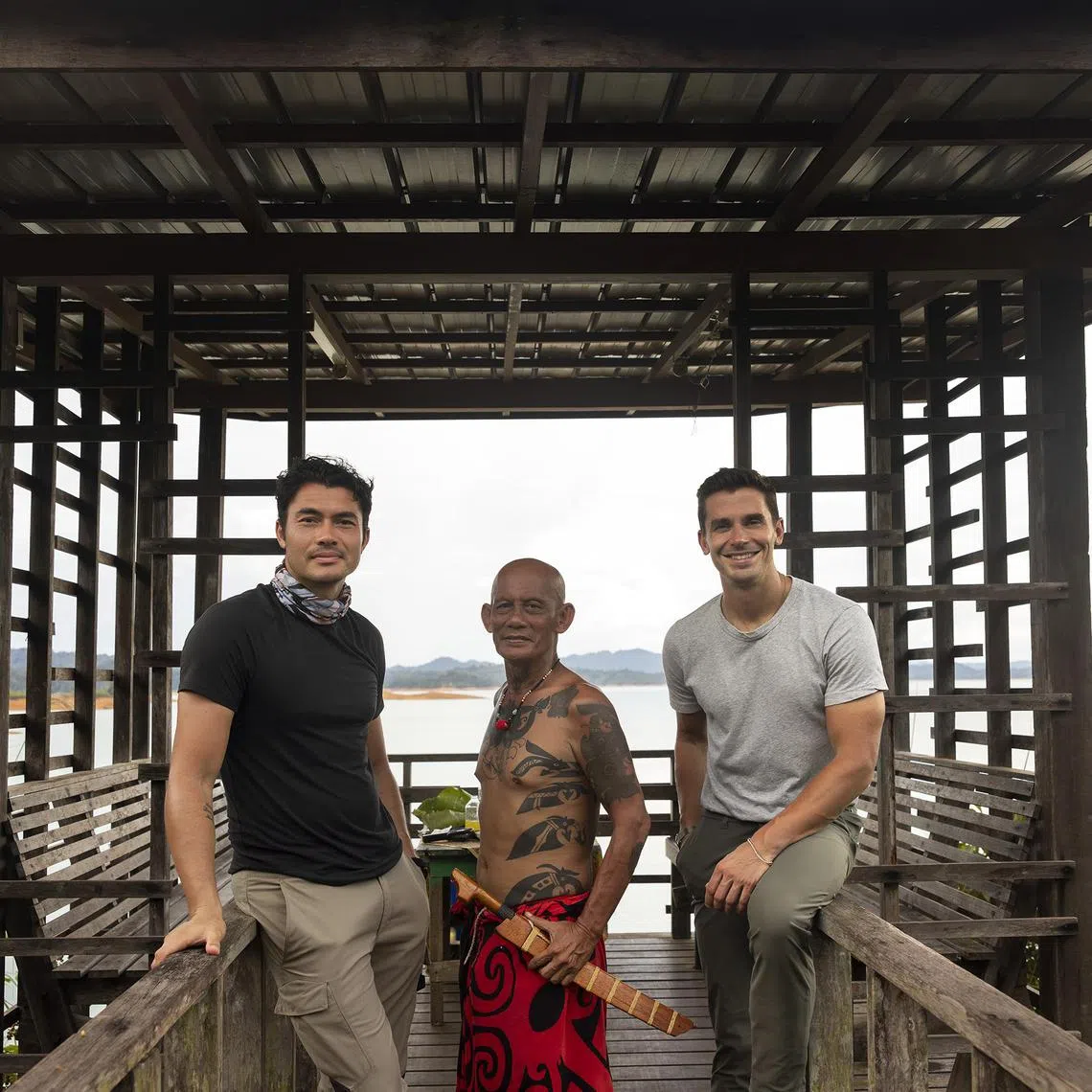 adtv05 - Henry Golding (left) and Antoni Porowski (right) with a member of the Iban tribe in Borneo in No Taste Like Home With Antoni Porowski

Source/copyright: Disney+