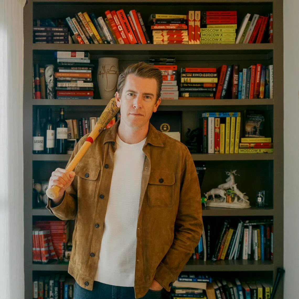 Author David McCloskey with a baseball bat signed by stars from the Cleveland Indians, the same bat that one of his characters, Artemis Aphrodite Procter, keeps in her office.