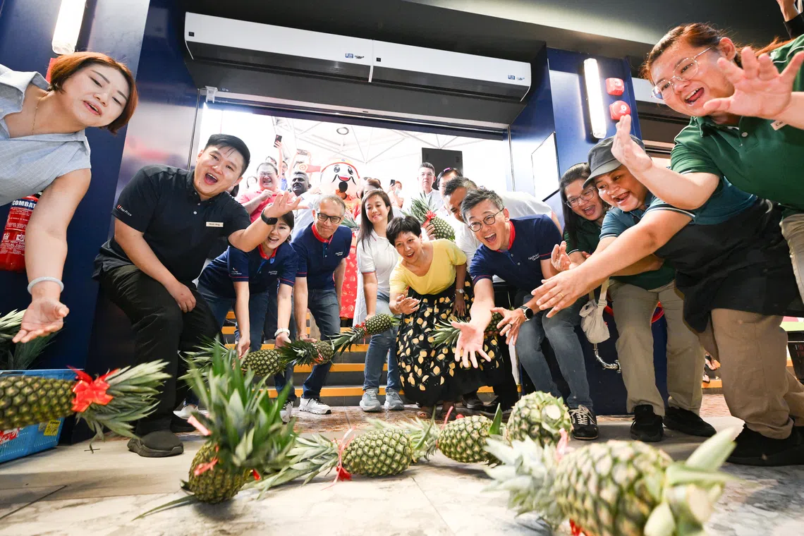Minister in the Prime Minister’s Office Indranee Rajah rolling her pineapple at the grand opening ceremony of FairPrice Elias Mall on Sept 20.