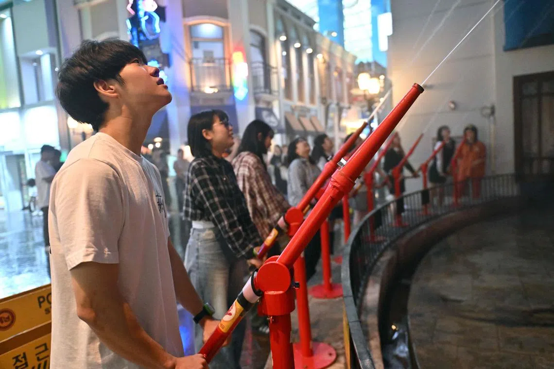 Visitors role-playing as firefighters during an adult-only event at the KidZania theme park in Seoul, on June 28, 2024.