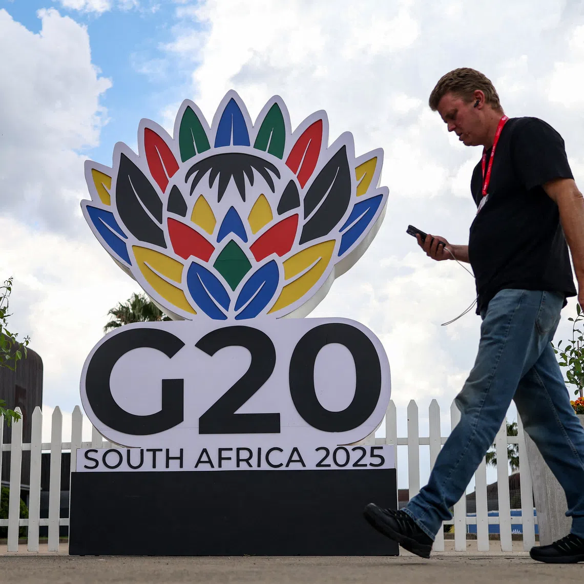 A man walks past a G20 South Africa 2025 sign inside the secured area of the G20 Summit venue at the Nasrec Expo centre, ahead of the summit scheduled for November 22–23 in Johannesburg, South Africa. November 21, 2025. REUTERS/Siphiwe Sibeko