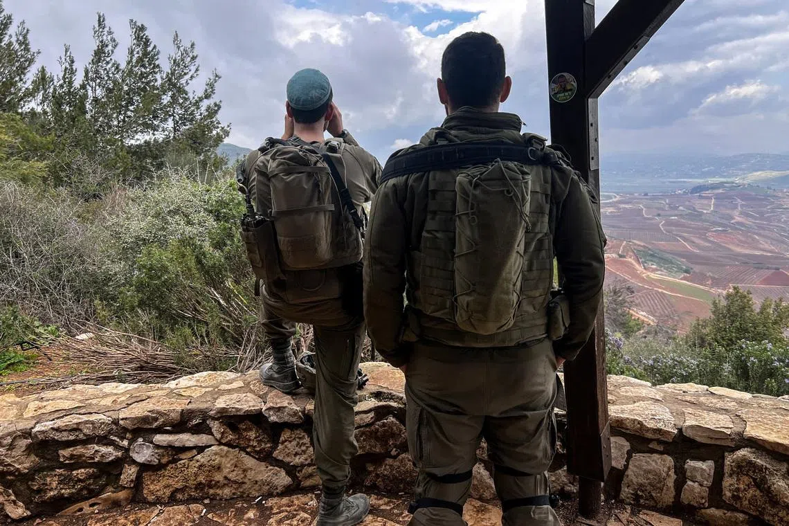 Israeli soldiers look towards Lebanon, amid an escalation between Iran-backed Hezbollah and Israel, and amid the U.S.-Israeli conflict with Iran, by the Israel-Lebanon border in northern Israel March 7, 2026. REUTERS/Avi Ohayon