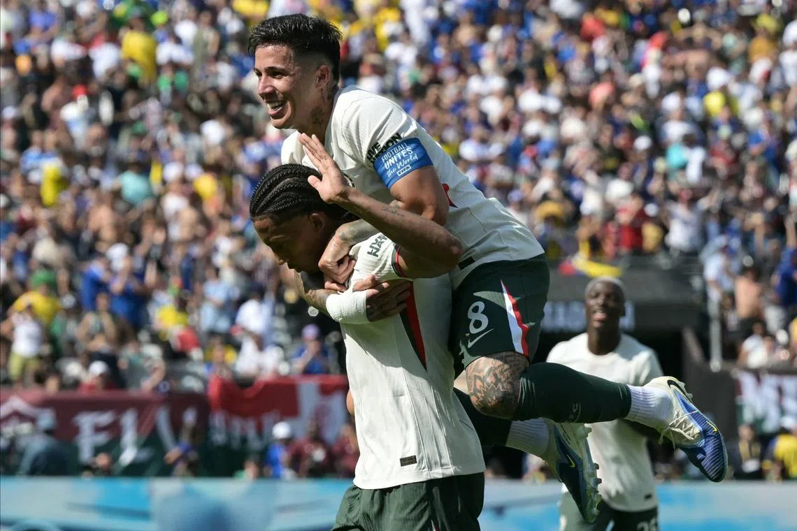 Chelsea's Brazilian forward Joao Pedro celebrates scoring his team's second goal with Argentinian midfielder Enzo Fernandez.