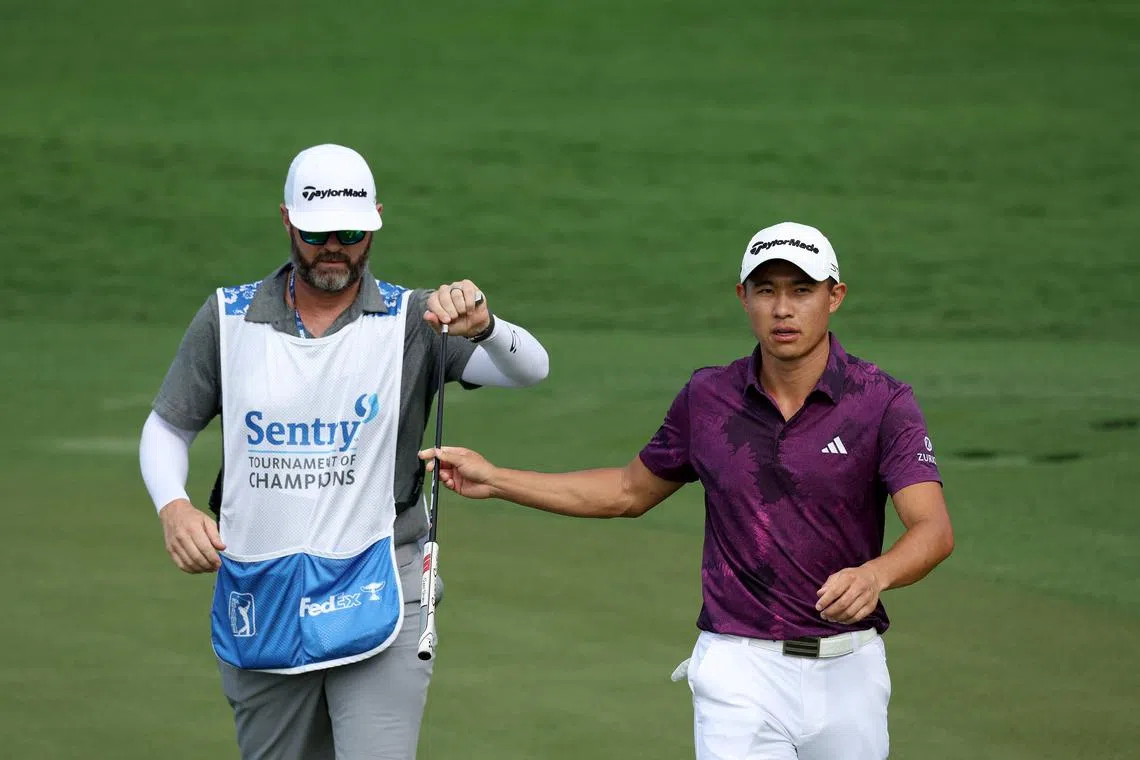 Collin Morikawa hands his club to caddie Jonathan Jakovac after making birdie on the 16th green during the third round of the Sentry Tournament of Champions.