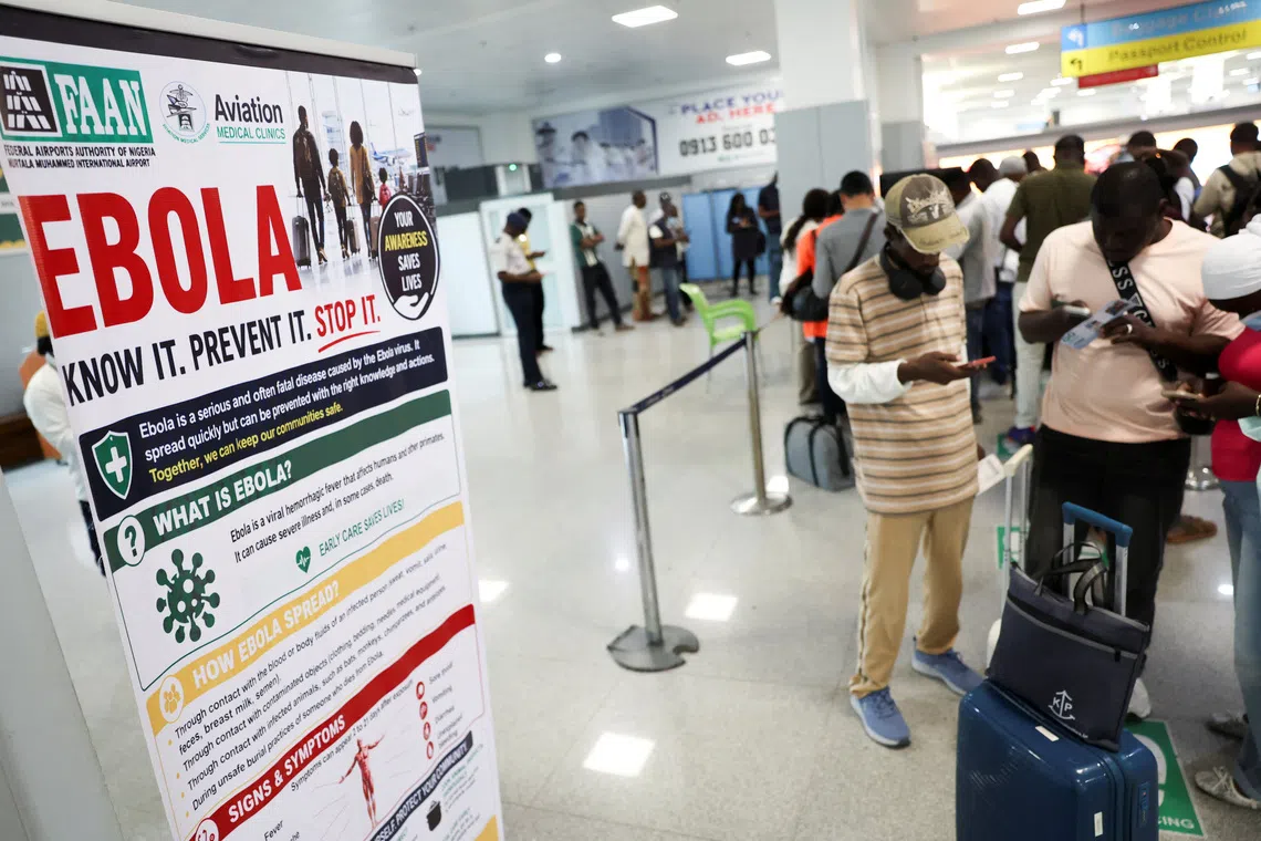 Travellers stand next to a banner displayed by a health screening station at Murtala Muhammed International Airport following reports of an Ebola case in Nigeria, in Lagos, Nigeria, October 22, 2026. REUTERS/Sodiq Adelakun