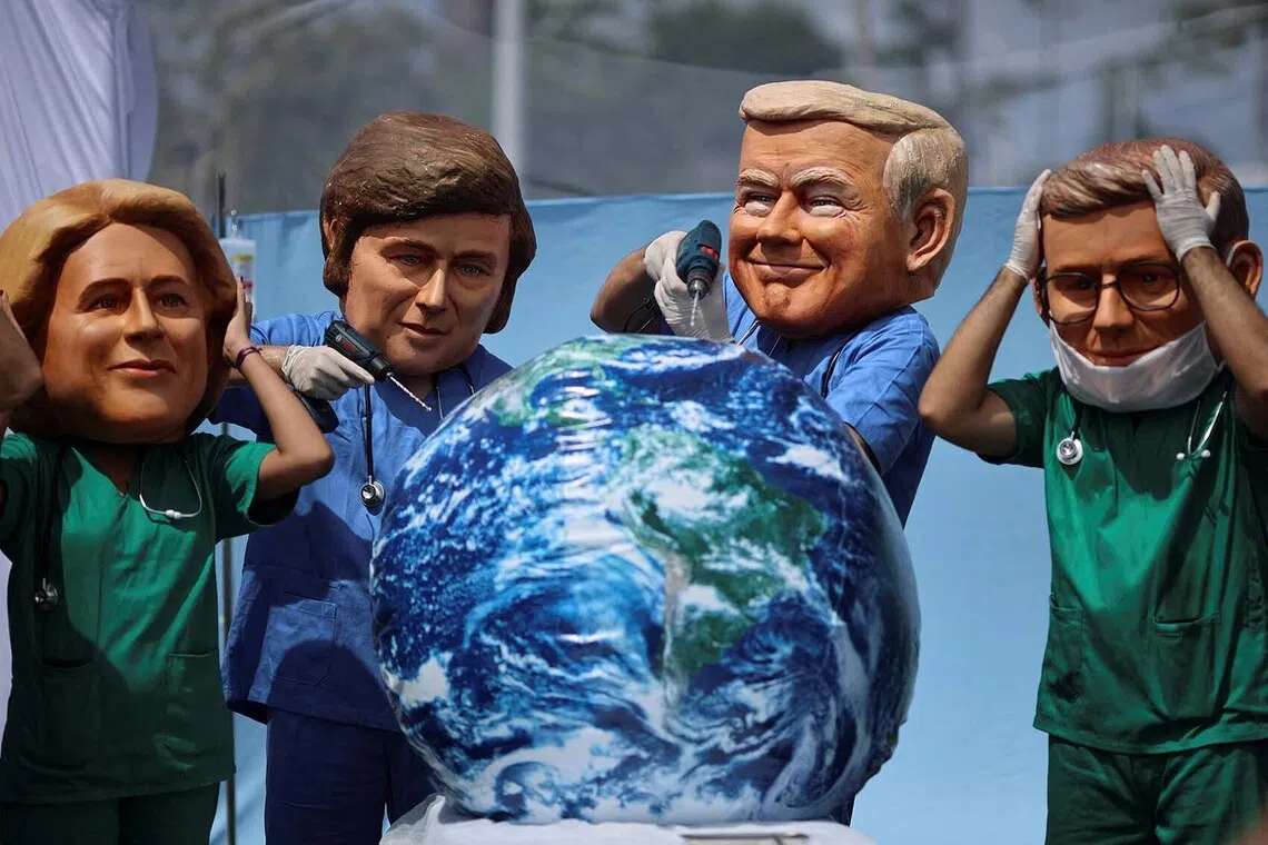 Oxfam activists wearing big head masks depicting world leaders stage a mock emergency room scene symbolizing a dying Planet Earth to call for urgent climate action during the UN Climate Change Conference (COP30), in Belem, Brazil, November 20, 2025. REUTERS/Adriano Machado TPX IMAGES OF THE DAY