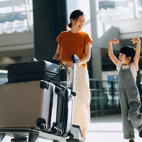 Best luggage brands in Singapore: Mum and child in airport with luggage