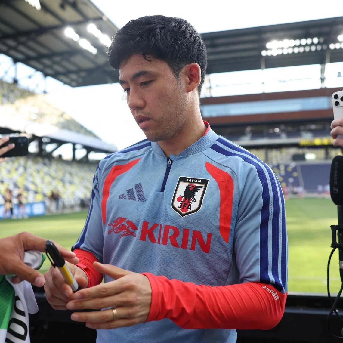 Japan's Wataru Endo signing autographs for fans during an open training session in Nashville on June 8.