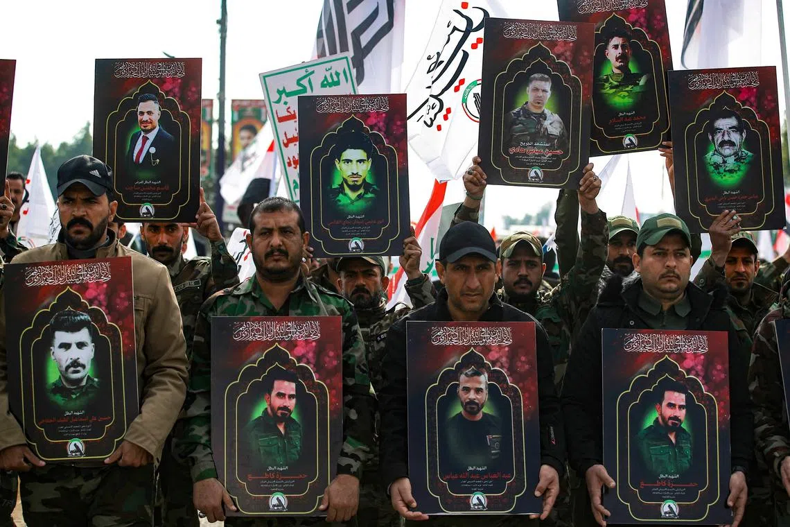 Members of Iraq's Hashed al-Shaabi carry portraits of people killed in January in US strikes following the death of three US soldiers.
