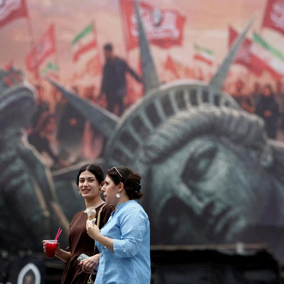 People walking past an anti-US billboard on a street in Tehran, Iran, on Aug 3.
