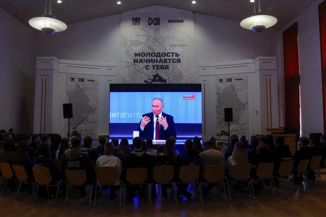People watch the live broadcast of Russian President Vladimir Putin's annual televised year-end press conference and phone-in, in the course of Russia-Ukraine conflict at a cultural centre in Donetsk, Russian-controlled Ukraine, December 19, 2024. REUTERS/Alexander Ermochenko
