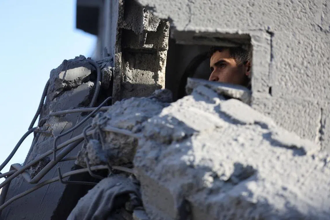 A Palestinian man inspects the damage at the site of Israeli strikes on houses, amid the ongoing conflict between Israel and the Palestinian Islamist group Hamas, in Khan Younis in the southern Gaza Strip, December 10, 2023. REUTERS/Ibraheem Abu Mustafa