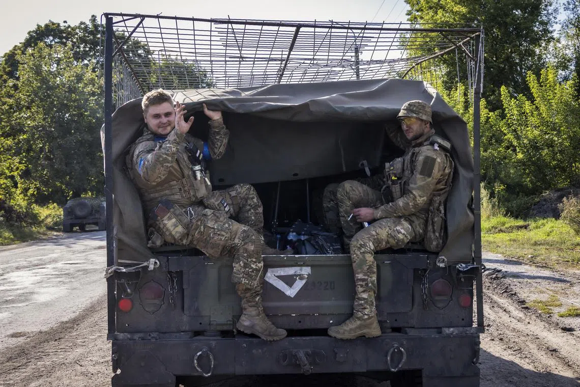 Ukrainian servicemen riding in the back of a military vehicle not far from the Ukraine-Russia border, on Aug 15.