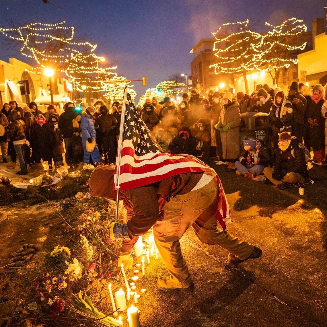 Demonstrators place candles and flowers at a makeshift memorial at the site where Alex Jeffrey Pretti was killed.
