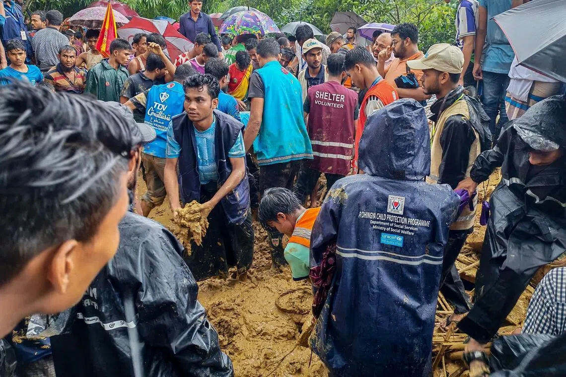 Bangladesh rescue personnel and volunteers work at the site of a landslide triggered by heavy rains at a school in the Kutupalong refugee camp in Cox’s Bazar on July 8.