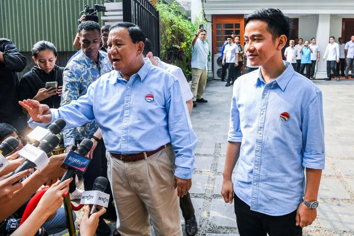 Indonesia's Defence Minister and presidential candidate, Prabowo Subianto (left), along with his running mate, Gibran Rakabuming Raka, speak to journalists before registering themselves for next year's presidential election.