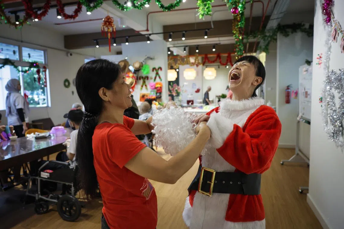 ST20241121_202453500735: Gin Tay/ clstranger/ Cherie Lok /
Profile of Janet Lee, (right)59, volunteer, donning a Santa Claus costume at Kang Le Day Hospice, on Nov 21, 2024.
She is assisted by helper, Anita Iglipa, 50.