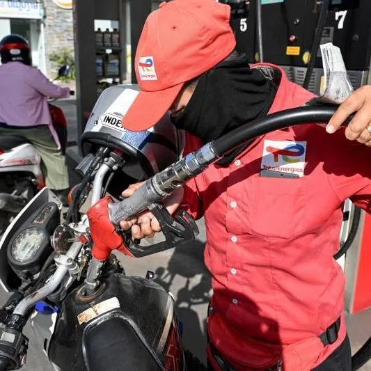 An employee pumping petrol into the vehicle of a customer at a gas station in Phnom Penh on March 9.