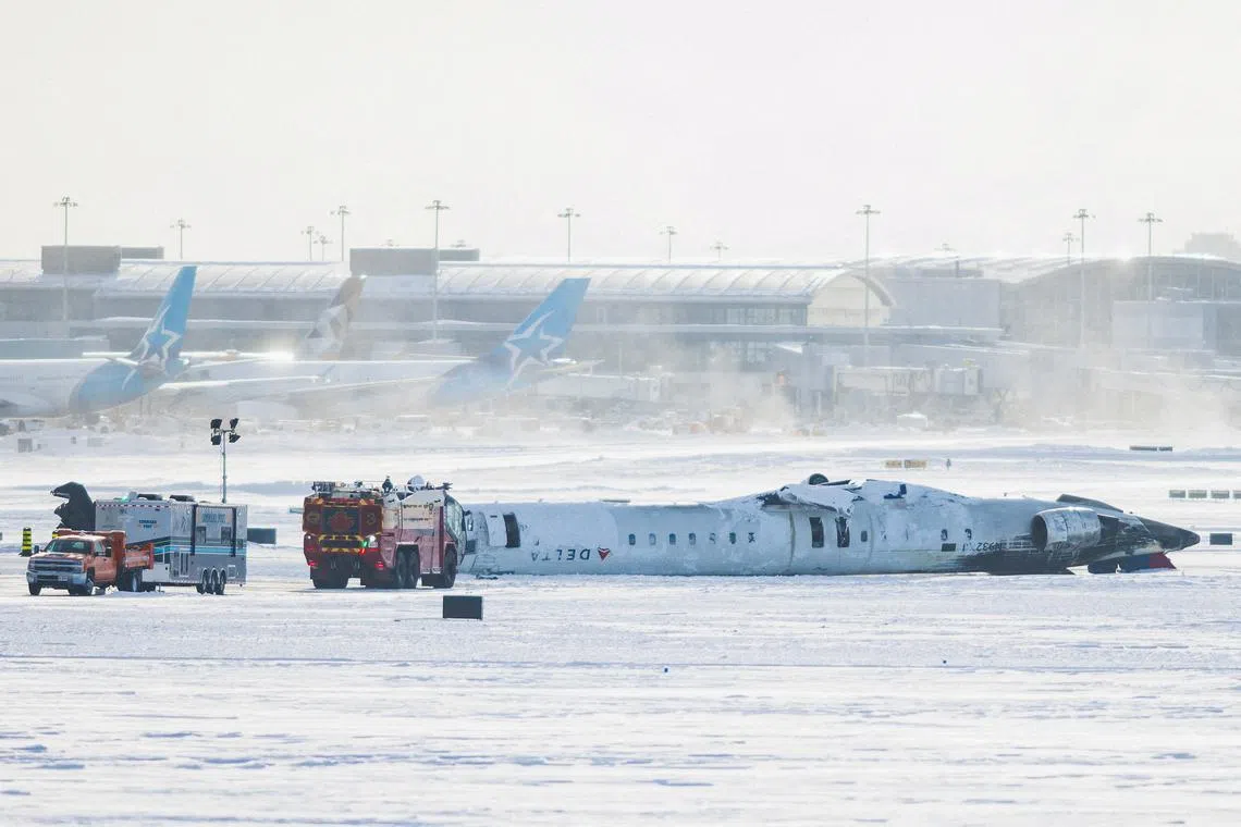 The wreckage of a Delta Air Lines-operated CRJ900 aircraft lays on the runway after a plane crash at Toronto Pearson International Airport in Mississauga, Ontario, Canada February 18, 2025. REUTERS/Cole Burston