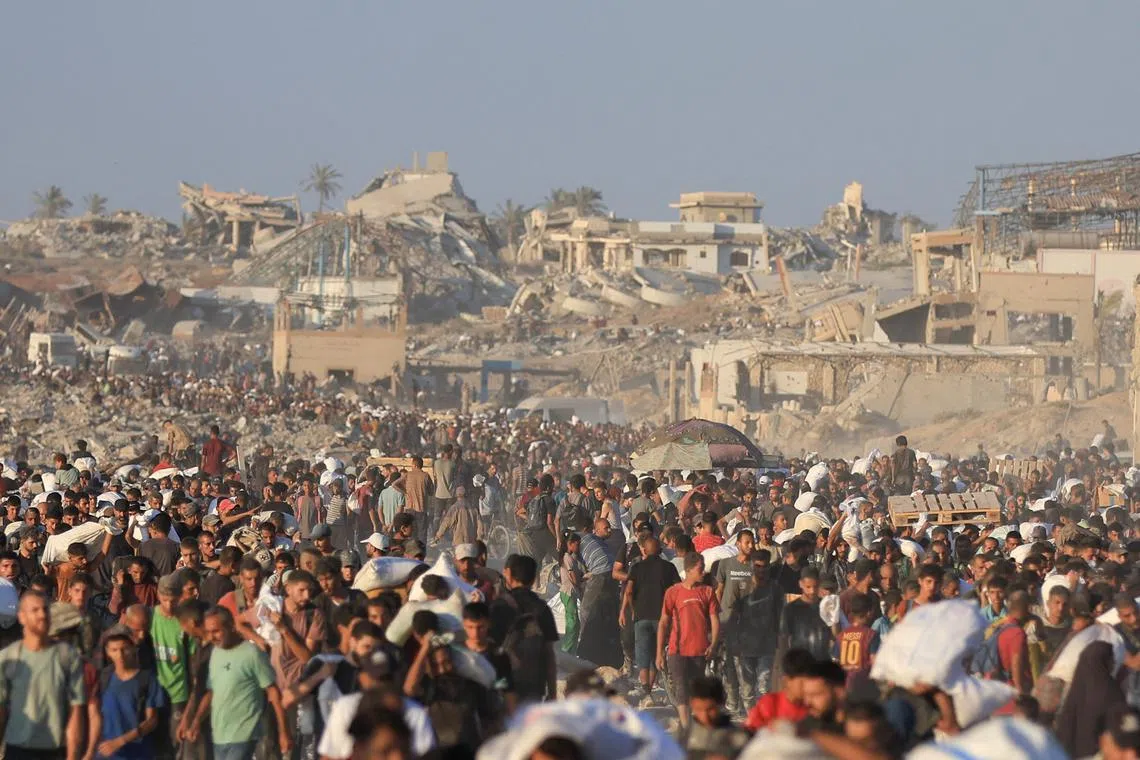 Palestinians carry aid supplies that entered Gaza through Israel, in Beit Lahia in the northern Gaza Strip, July 30, 2025. REUTERS/Dawoud Abu Alkas