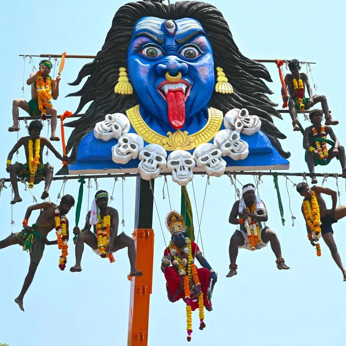 Tamil devotees suspended in air from a crane by piercing themselves onto metal hooks to honour the Hindu God Murugan during Panguni Uthiram festival in Mumbai on April 1, 2026. 