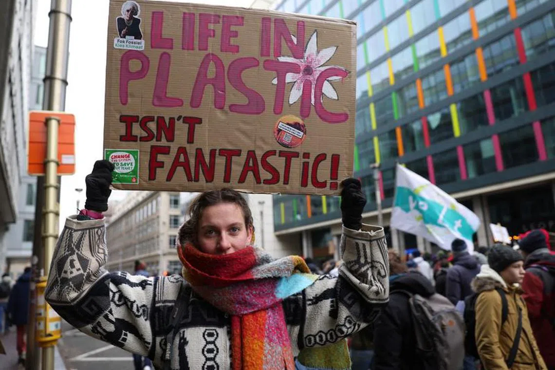 A demonstrator holds a placard, during a climate protest coinciding with COP28 being held in Dubai and ahead of the upcoming Belgian presidency of the Council of the European Union, in Brussels, Belgium, December 3, 2023. REUTERS/Johanna Geron