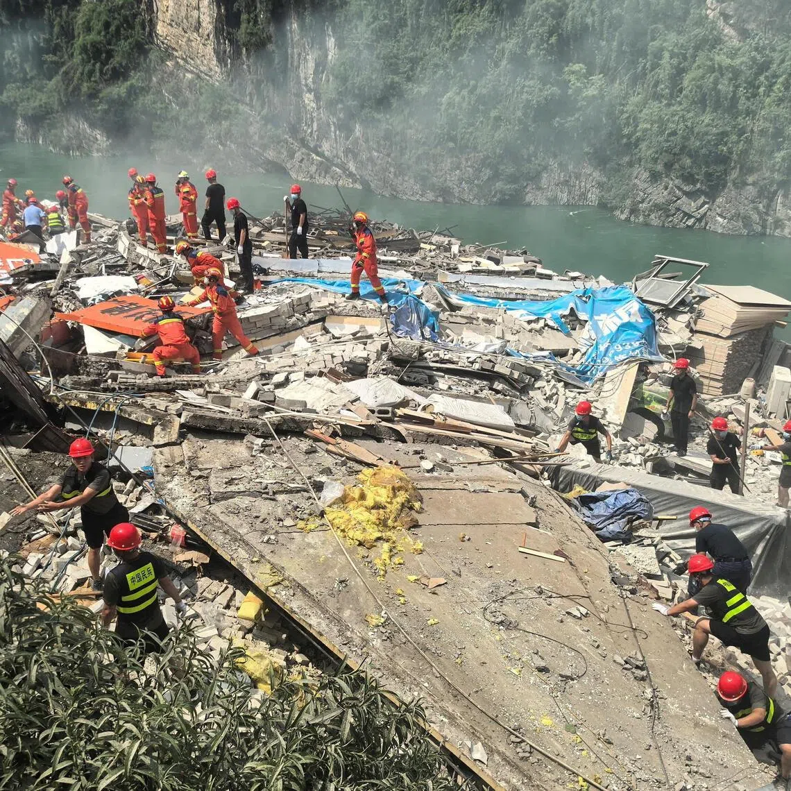Rescue workers search for survivors at the site of the landslide in Chongqing on July 17.