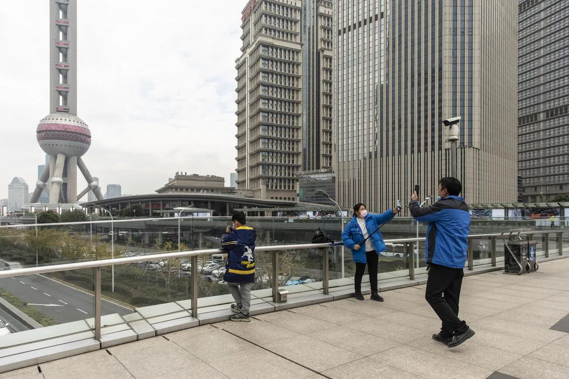 Sightseers at a walkway in the Lujiazui Financial District in Shanghai, China, on Thursday, Dec. 8, 2022. A new policy on Wednesday to ease intercity movement may increase spending but also spread illness. (Qilai Shen/The New York Times)