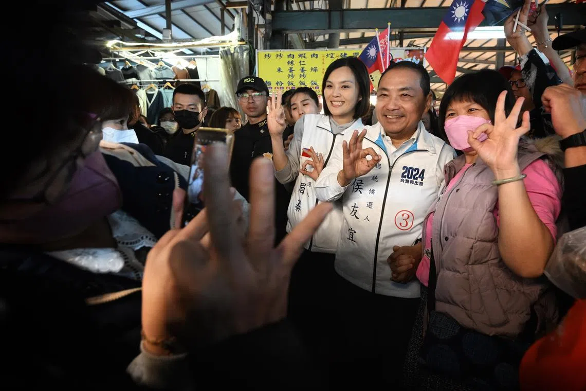 Hou Yu-ih, the KMT presidential candidate, posing for photos with supporters during a visit to a market in Kaohsiung on Jan 10, 2024. 