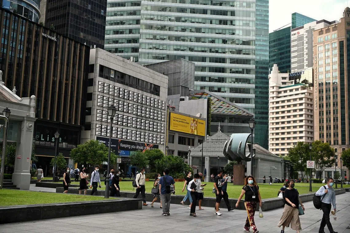 Office workers on their way to work at Raffles Place MRT in the morning of March 29, 2022. 