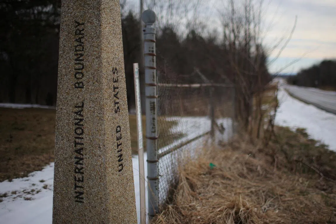 FILE PHOTO: A marker indicating the boundary between the United States and Canada is pictured in Champlain, New York, U.S., March 26, 2024.   REUTERS/Brian Snyder/File Photo