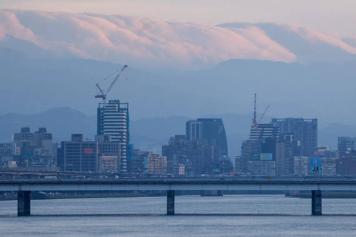 A view of the Taipei skyline with clouds hanging over distant mountains, seen from across the Tamsui River in Taipei, Taiwan, November 8, 2025. REUTERS/Ann Wang