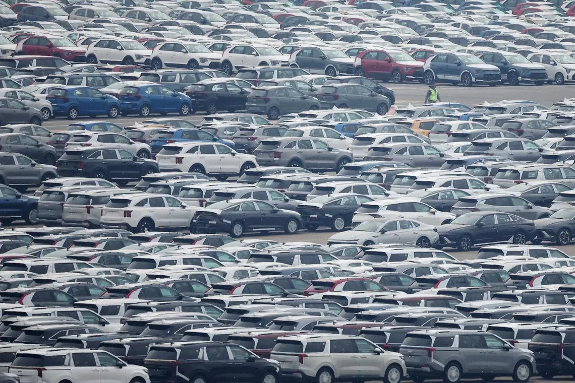 FILE PHOTO: A worker walks past cars made by South Korea's automaker Kia Motors which is a sister company of South Korea’s biggest automaker company Hyundai Motors at the company's shipping yard at a port in Pyeongtaek, South Korea, April 2, 2025.   REUTERS/Kim Hong-Ji/File Photo