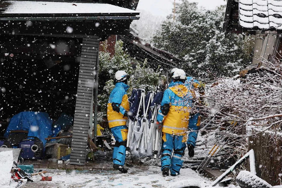Rescuers conduct searches for survivors as snow hampers rescue operations in the city of Suzu on Jan 7.