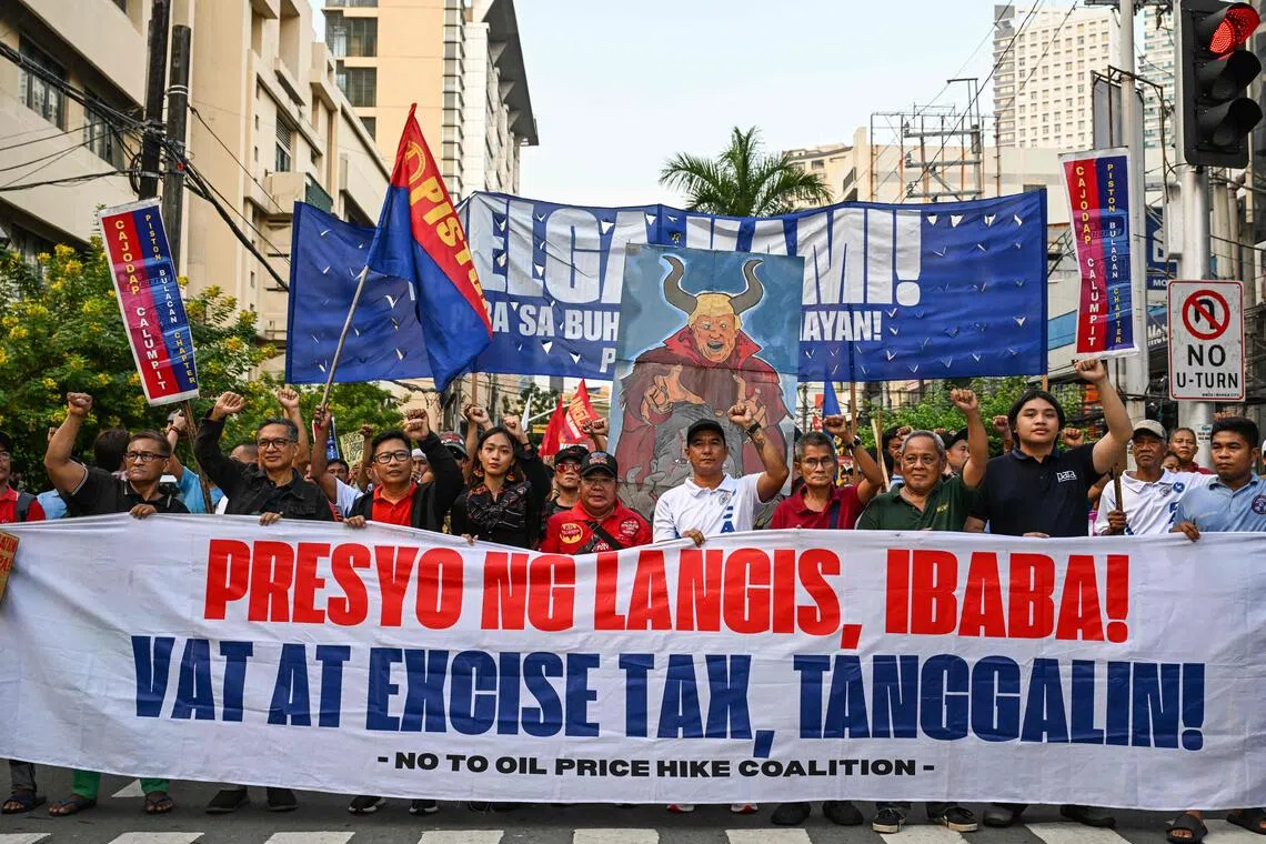 Protesters march along a Manila street to press for a rollback in oil prices and removal of value-added and excise taxes.