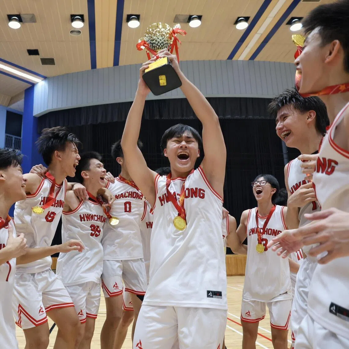 Hwa Chong Institution captain Wong Ye-En lifting the trophy after they beat ACS(I) to win the National School Games A Division boys' basketball final on May 22.