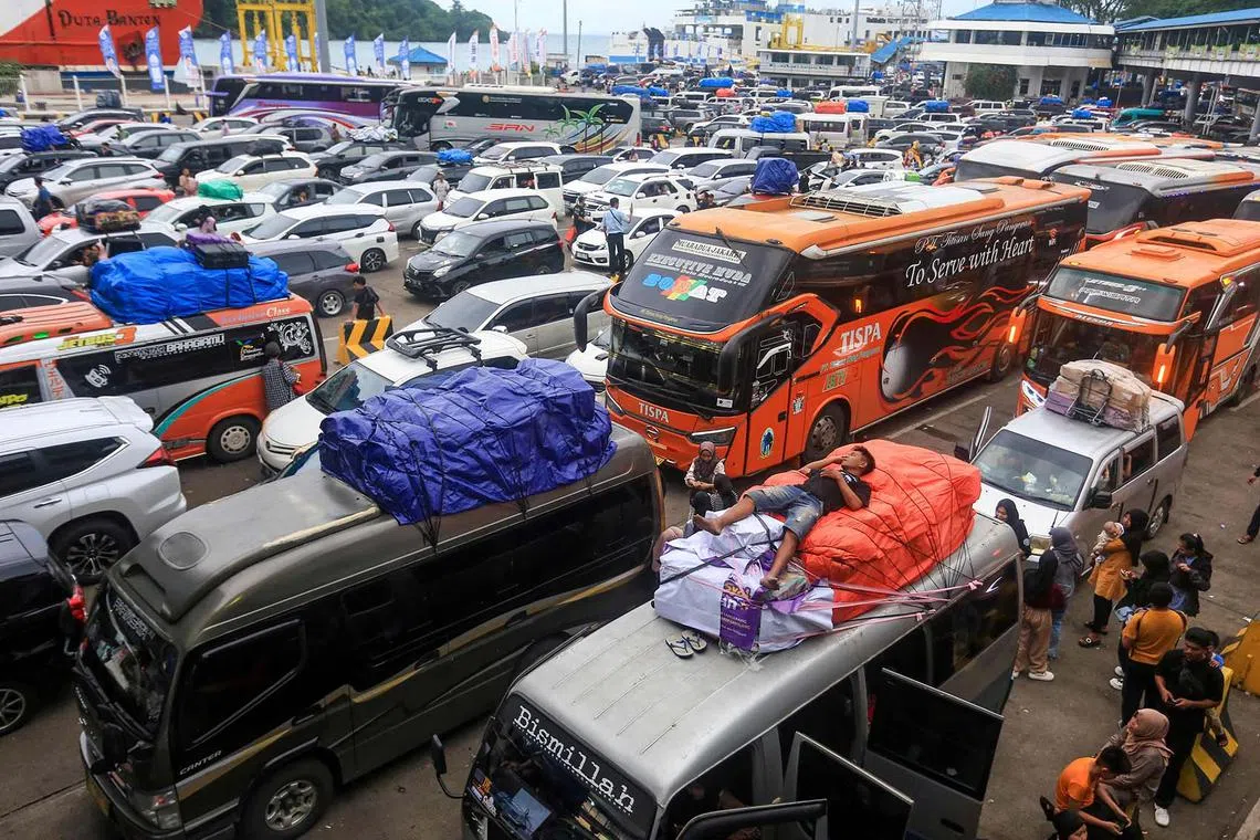 TOPSHOT - A man falls asleep on top of a vehicle as prospective homecoming travellers crowd Merak Port in Cilegon on March 28, 2025, to celebrate Eid al-Fitr to mark the end of Ramadan. (Photo by DZIKI OKTOMAULIYADI / AFP)