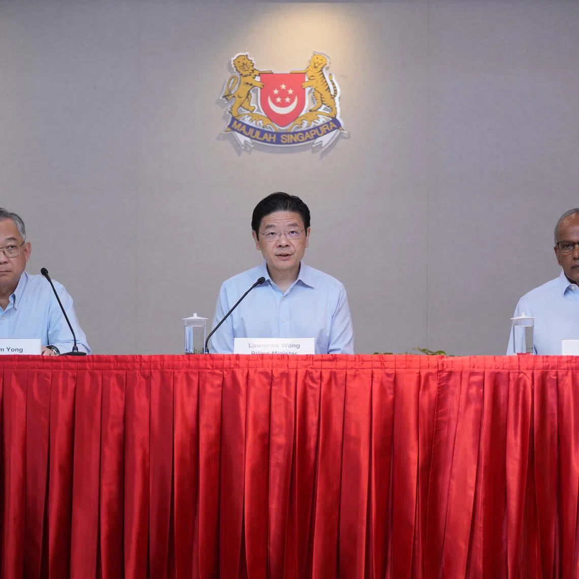PM Lawrence Wong (centre) with DPM Gan Kim Yong (left) and Mr K. Shanmugam at a press conference on May 21.
