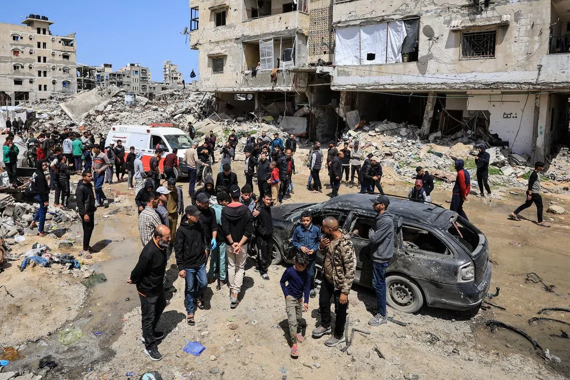 Palestinians inspect the damage after a person was hit by an Israeli strike while riding a bicycle, according to medics, in Gaza City, April 6, 2026. REUTERS/Dawoud Abu Alkas