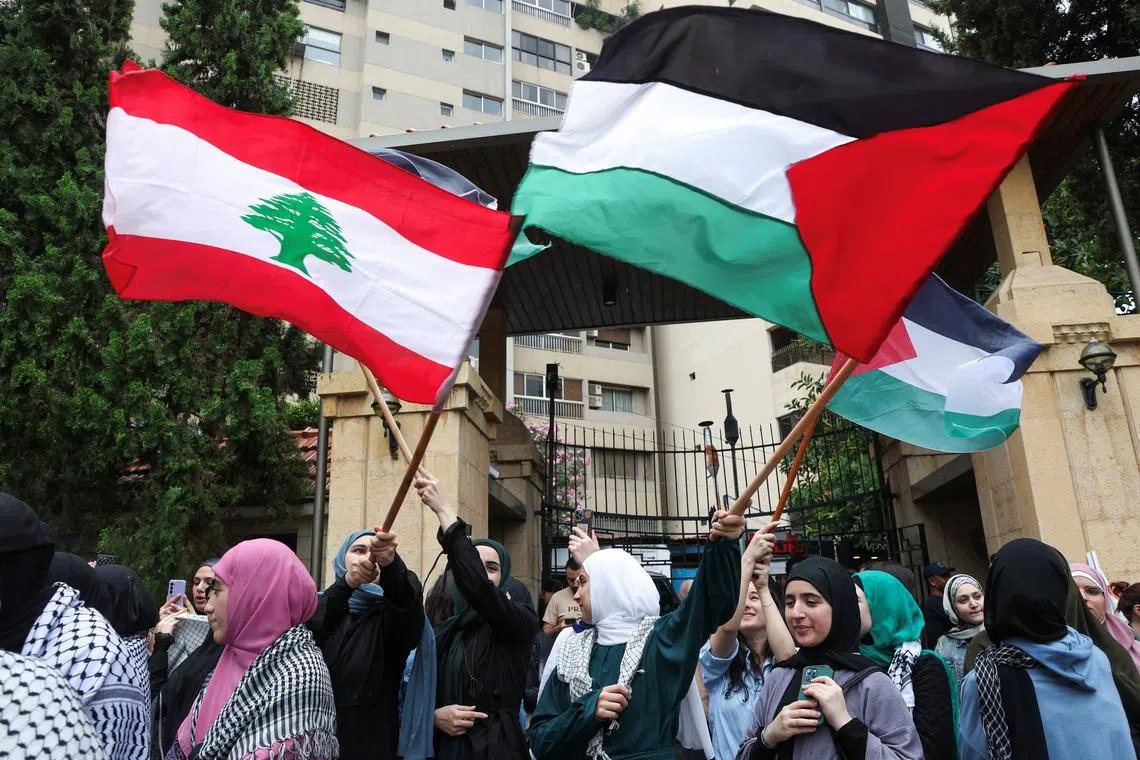 Demonstrators hold Lebanese and Palestinian flags during a protest in solidarity with Gaza at the Lebanese American University (LAU), in Beirut, Lebanon April 30, 2024. REUTERS/Mohamed Azakir