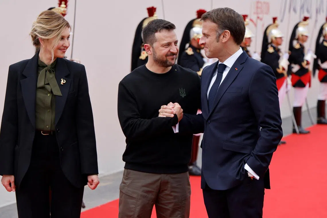 France's President Emmanuel Macron (right) greeting Ukrainian President Volodymyr Zelensky and his wife Olena Zelenska upon their arrival at the World War II "D-Day" commemoration.