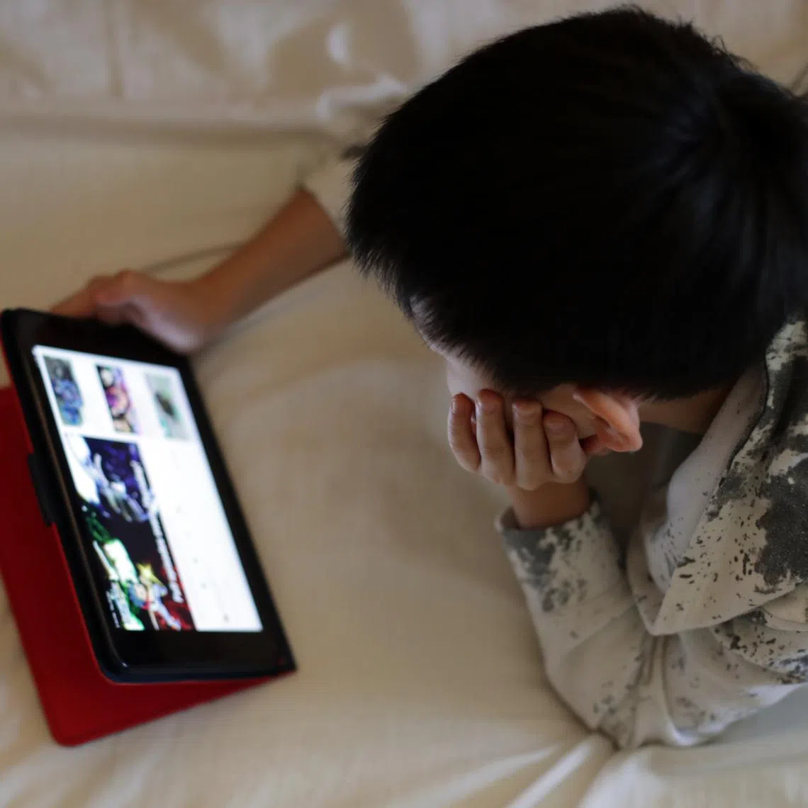 A child watching a video on his ipad at home during the circuit breaker period on Apr 25, 2020.