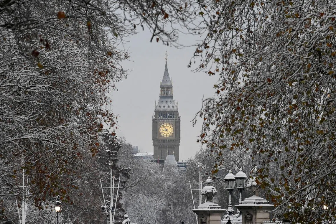 FILE PHOTO: Trees are covered in snow in front of The Elizabeth Tower, more commonly known as Big Ben, as cold weather continues, in London, Britain, December 12, 2022. REUTERS/Toby Melville/File Photo