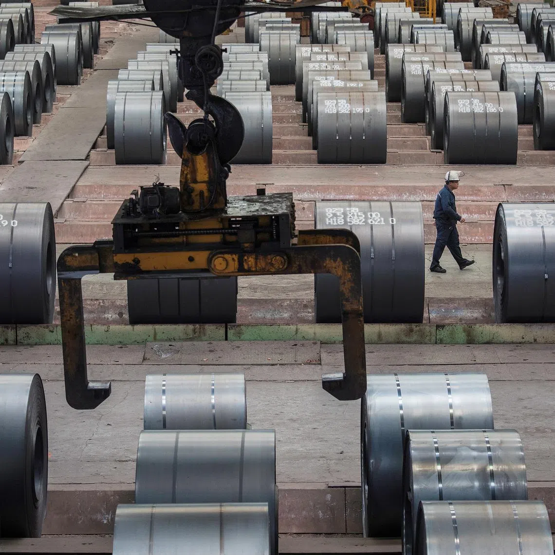 A worker walks past steel rolls at the Chongqing Iron and Steel plant in Changshou, Chongqing, China August 6, 2018. Picture taken August 6, 2018. REUTERS/Damir Sagolj