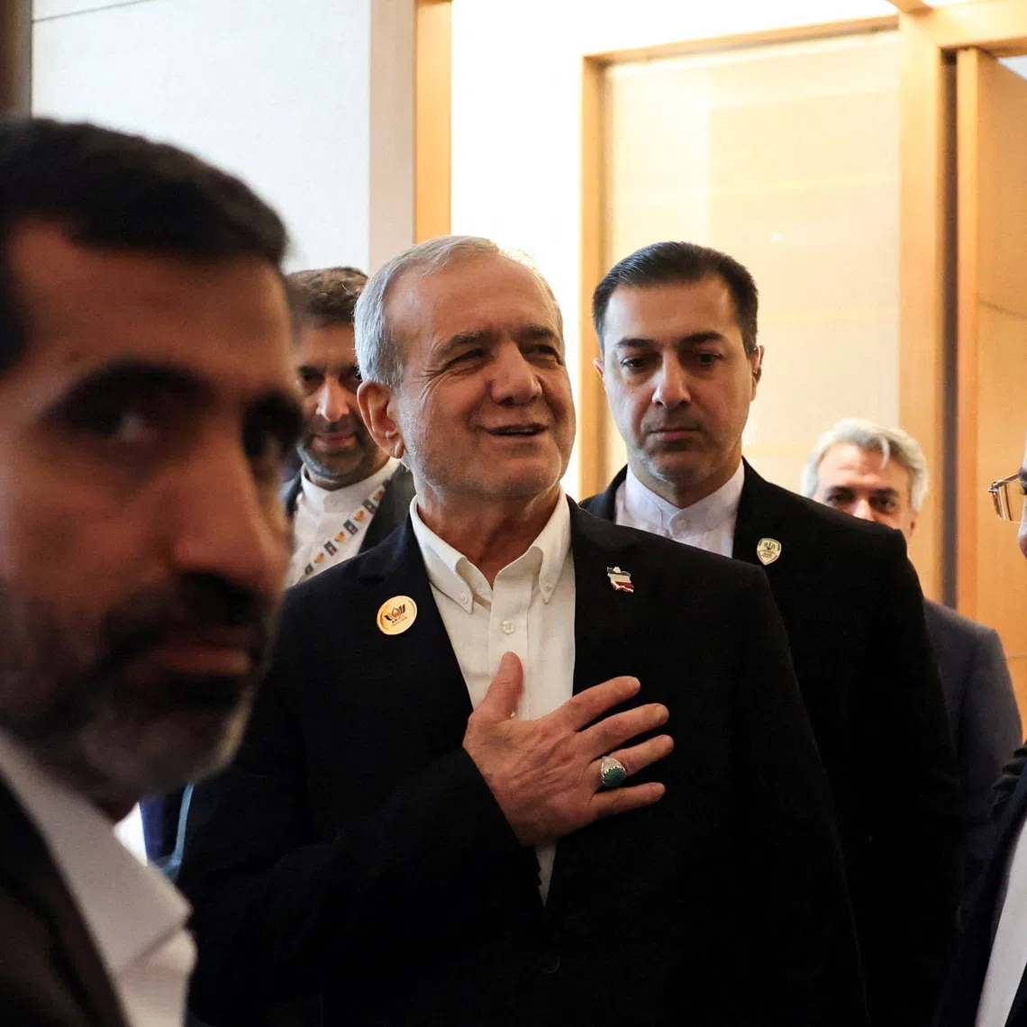 Iranian President Masoud Pezeshkian reacts as he is greeted inside a hotel, during his visit to India to attend the 18th BRICS Summit, in New Delhi, on Sept 12.